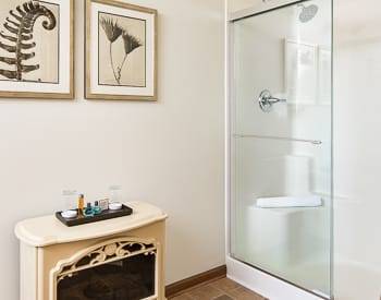 Nice clean White Shower stall with a freestanding electric fireplace.